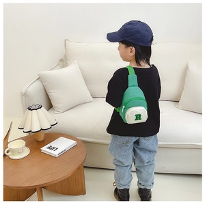 Kids trendy color-block nylon chest bag with letter R patch worn in a cozy room