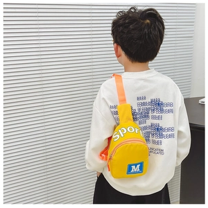 Detail der gelben Kinder-Brusttasche mit M-Patch und verstellbarem orangefarbenem Gurt