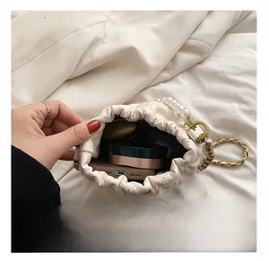 Interior view of white pearl bucket bag showing capacity for phone and cosmetics