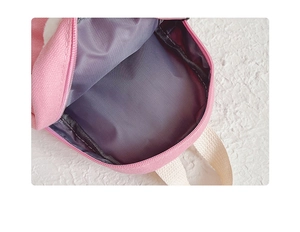 Detail view of pink canvas backpack interior showing grey lining and smooth zipper
