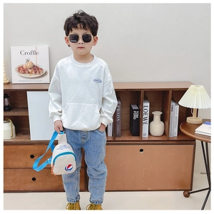 Détail du mini sac bandoulière blanc avec motif basket sur un sweat blanc pour enfant