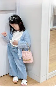 Pink quilted bucket bag with pearl chain shown as part of a stylish girl's spring outfit