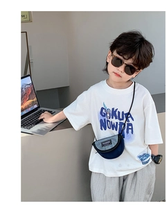 Vue détaillée du sac bandoulière enfant en toile et du t-shirt blanc graphique