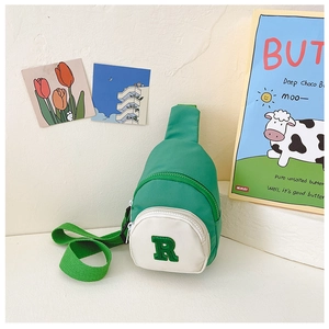 Close-up of boys green and white nylon chest bag with R embroidery and adjustable strap