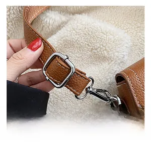 Détail de la bandoulière réglable du sac en cuir marron grainé avec boucle argentée