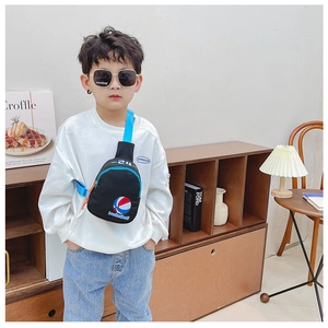 Détail du sac de poitrine enfant en toile noire avec sangle bleue et motif basketball