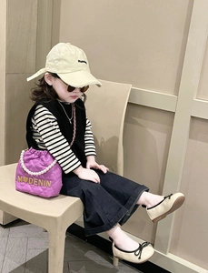 Fashionable girl wearing a purple quilted crossbody bag with pearl strap and casual outfit