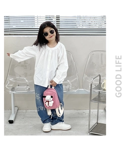 Pink toddler canvas backpack with a cute white puppy plush charm shown on a model