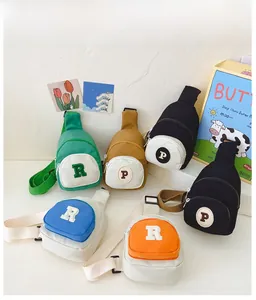 Detailed view of colorful canvas kids' crossbody bags with embroidered letter patches