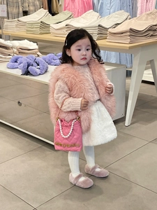 Detailed view of pink quilted girls' handbag with pearl handle and plush fashion outfit