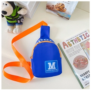 Nahaufnahme der blauen Brusttasche aus Nylon mit M-Print und orangefarbenem Gurtband