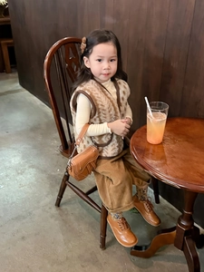 Détail d'un ensemble mode enfant avec gilet léopard en fausse fourrure et sac selle
