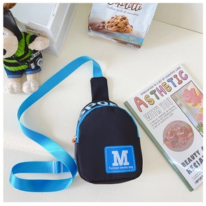 Detail der Kinder-Brusttasche in Schwarz und Blau mit M-Print und Sport-Reißverschluss