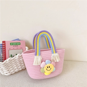 Pink woven cotton rope handbag for kids with rainbow handles and a smiley sunflower decoration