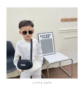 Close-up of kids canvas crossbody bag with white GAME lettering and stylish sunglasses