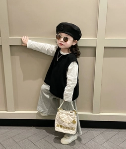 Fashionable young girl wearing white quilted handbag with pearl chain and trendy outfit