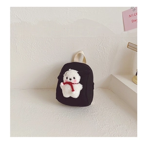 Detail of a mini black canvas toddler backpack with a cute 3D plush doll decoration
