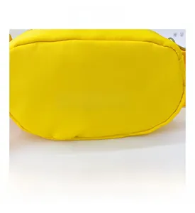 Detail shot of a bright yellow canvas kids crossbody bag featuring a white GAME print