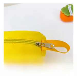 Detailed macro view of heart-shaped metal zipper puller on yellow canvas crossbody bag