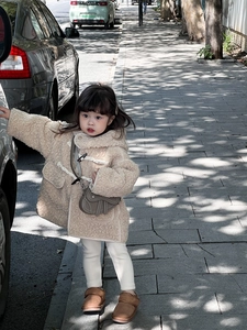 Détail d'une veste polaire beige à boutons bûche et sac besace gris pour petite fille