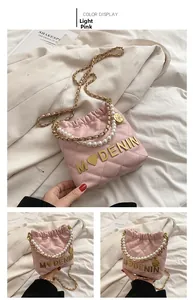 Detailed view of light pink quilted bucket bag with pearl handle and golden chain