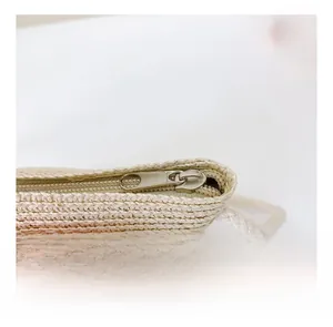 Détail de la fermeture éclair en métal argenté sur un sac en paille tressée pour enfants