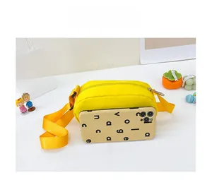 Size comparison of a yellow canvas crossbody bag next to a mobile phone case on a desk