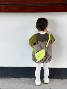 Vue arrière d'un enfant portant un mini sac selle jaune fluo avec boucle en métal et sangle