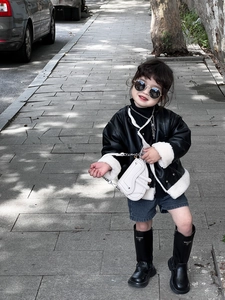 Jeune fille à la mode en veste de cuir portant un petit sac à bandoulière selle blanc