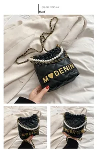 Detail of black quilted bucket bag for girls with pearl handle and golden metal lettering