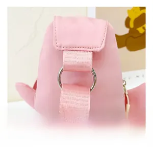 Gros plan sur l'anneau en D argenté et la bandoulière en toile rose du sac lapin
