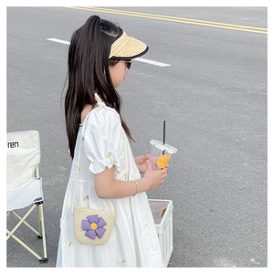 Détail d'un sac de plage en paille pour filles avec une fleur de tournesol violette vive