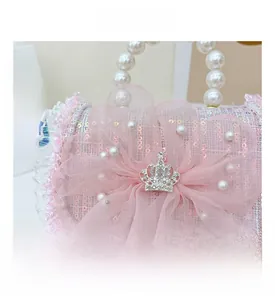 Detail of pink sequin weave bag with gauze flower, pearl handle and crown ornament