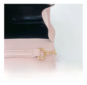 Détail du sac en cuir rose avec quincaillerie dorée, coutures lisses et pompons laser