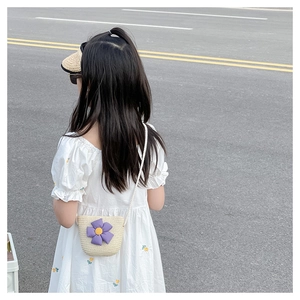 Détail du mini sac bandoulière en paille pour fille avec fleur mauve et sangle tressée