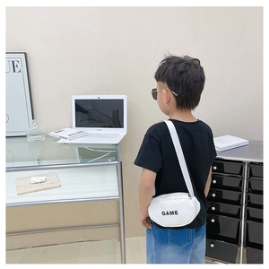 Detail of white children's crossbody bag featuring black GAME print and adjustable strap