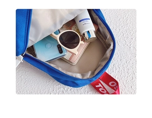 Detailed interior of blue canvas backpack showing large main compartment and accessories