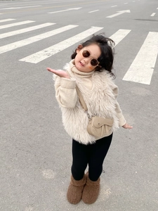 Détail d'un sac bandoulière selle en cuir beige pour fille avec une tenue d'hiver