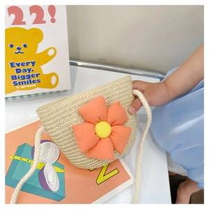 Détail du sac de plage en paille pour filles avec une grande fleur en tissu orange décorative