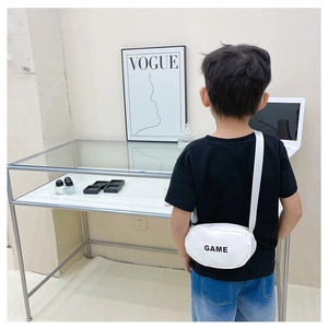 Detail view of the adjustable white canvas shoulder strap and GAME print on child bag