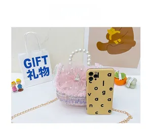 Mini sequin princess bag with pearl handle and crown charm shown next to a smartphone