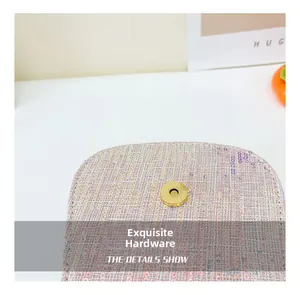 Detail of round gold metal buckle on light purple sequin woven crossbody bag