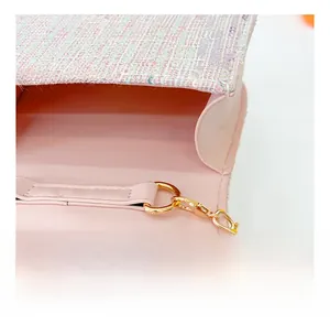 Close-up of pink tweed child handbag with shiny texture and golden metal buckle details