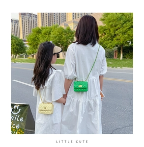 Détail de sacs bandoulière matelassés parent-enfant avec chaînes dorées vert et jaune