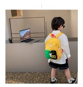 Detail of a yellow kids backpack with colorful contrast pockets and lovely letter prints