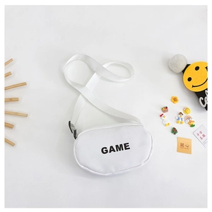 Detail of white canvas kids crossbody bag with black GAME print and cute accessories