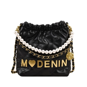Quilted black girl's bucket bag with pearl handle and camellia charm in crossbody style