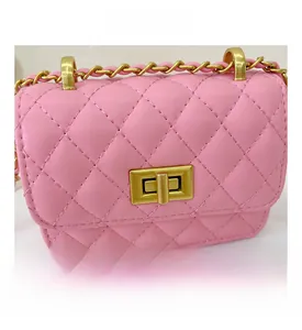 Gros plan d'un petit sac carré en cuir rose matelassé avec chaîne dorée et fermoir