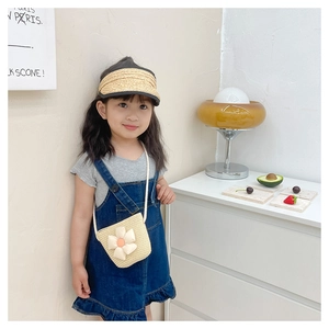 Détail du sac bandoulière en paille pour enfant avec fleur jaune et chapeau tressé