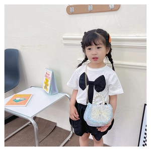 Close-up of kids crossbody bag featuring a large mesh flower and elegant pearl handle